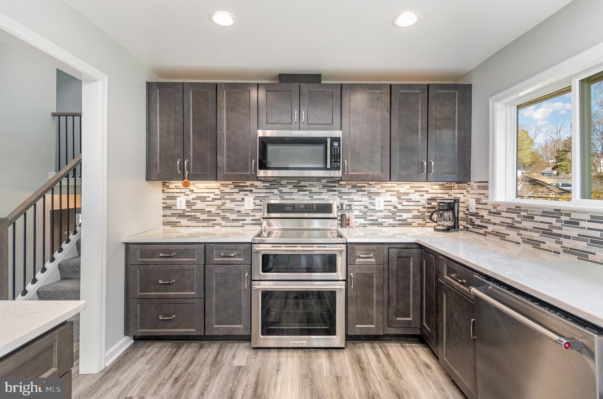 6932 Spelman Drive Springfield, VA 22153 - Photo 15 of 37 a kitchen with stainless steel appliances a stove sink and cabinets