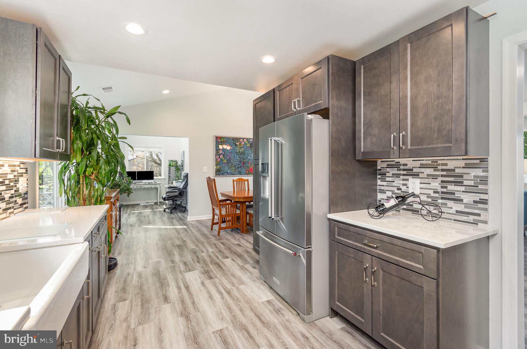 6932 Spelman Drive Springfield, VA 22153 - Photo 16 of 37 a kitchen with kitchen island a counter top space a sink stainless steel appliances and cabinets