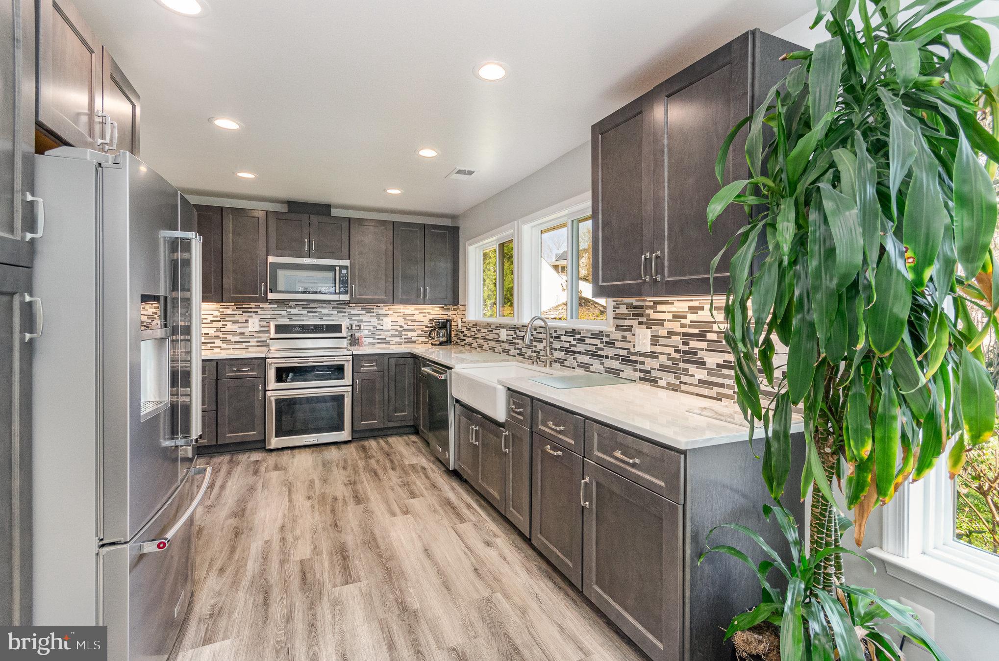 6932 Spelman Drive Springfield, VA 22153 - Photo 4 of 37 a kitchen with stainless steel appliances a sink stove and cabinets