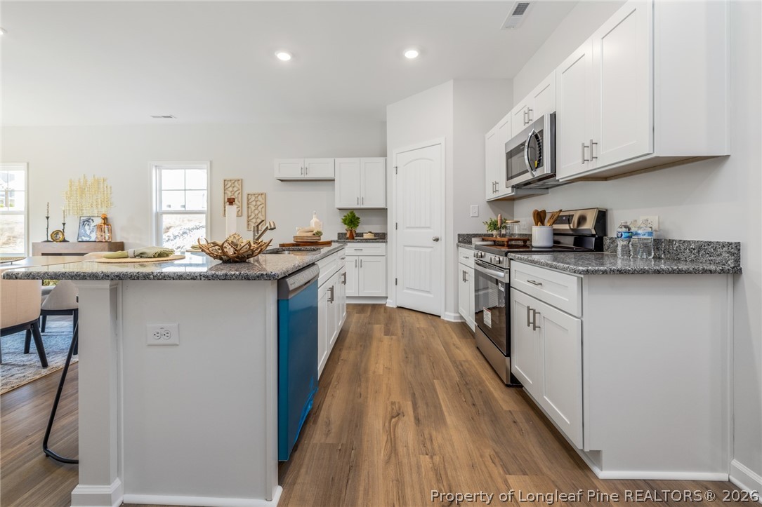 5421 Short Leaf (lot 109) Road Raeford, NC 28376 - Photo 14 of 29 a kitchen with stainless steel appliances granite countertop a sink a stove and cabinets