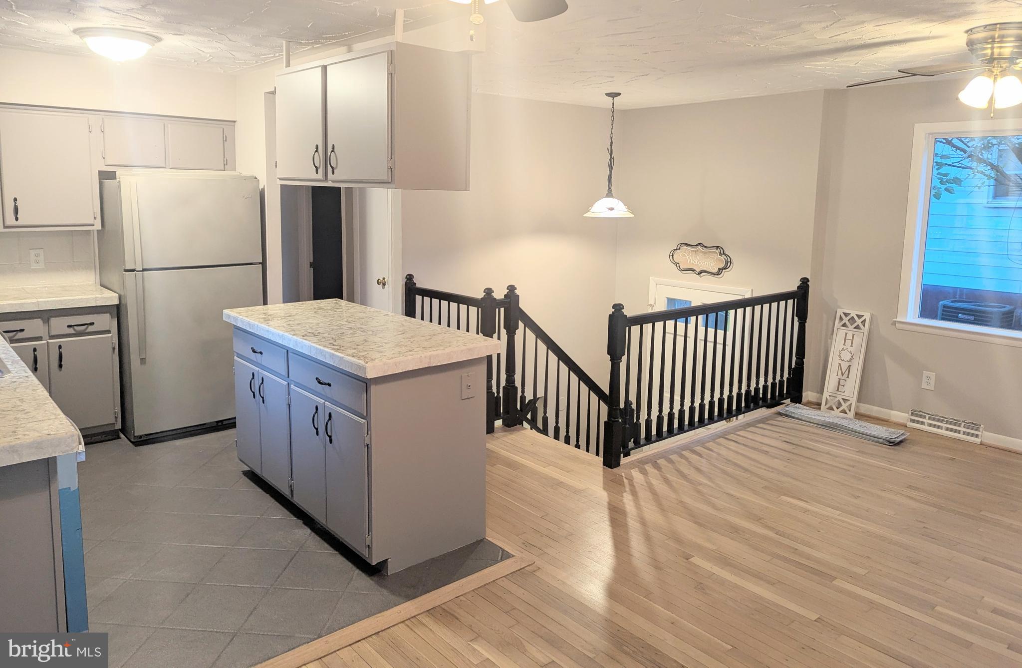 1712 Forestville Road Edgewater, MD 21037 - Photo 3 of 31 a kitchen with stainless steel appliances a refrigerator a sink a stove a dining table and chairs
