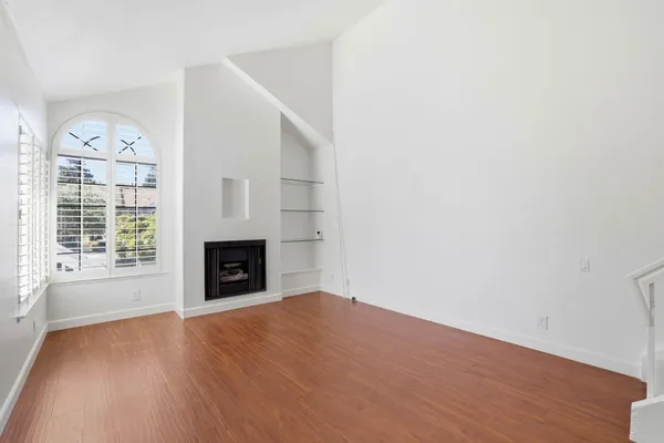 an empty room with windows and fireplace