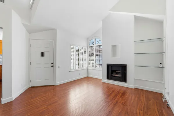 an empty room with windows and a fireplace