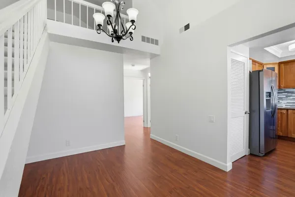 a view of a hallway with wooden floor and staircase