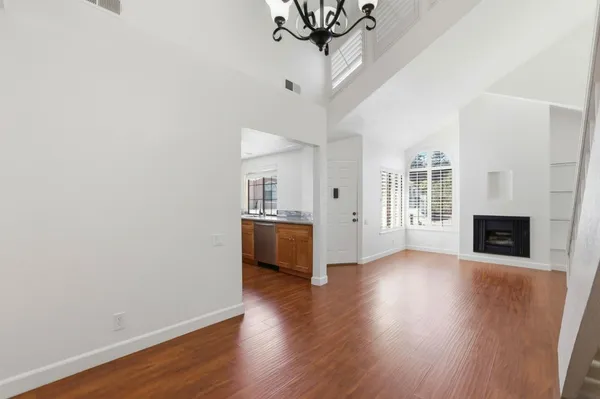 a view of a livingroom with wooden floor and a kitchen space