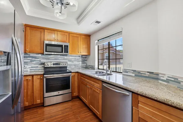 a kitchen with stainless steel appliances granite countertop a sink stove and microwave