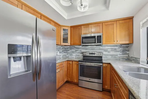 a kitchen with stainless steel appliances granite countertop a stove microwave and sink