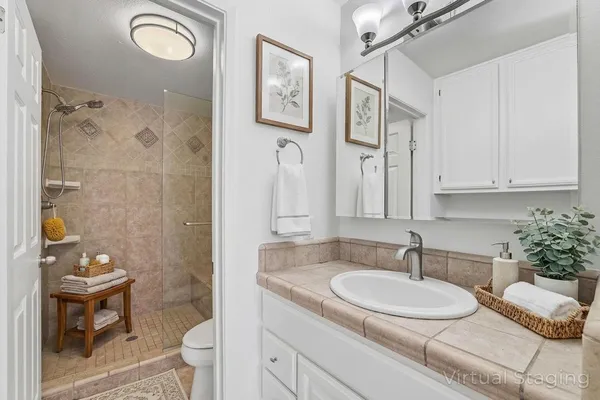 a bathroom with a granite countertop sink toilet and shower