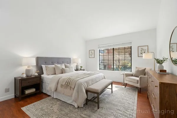 a bedroom with a bed a couch and a large window