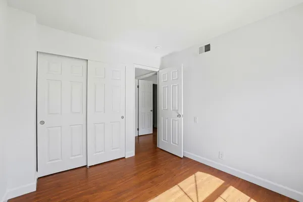 a view of an empty room with wooden floor