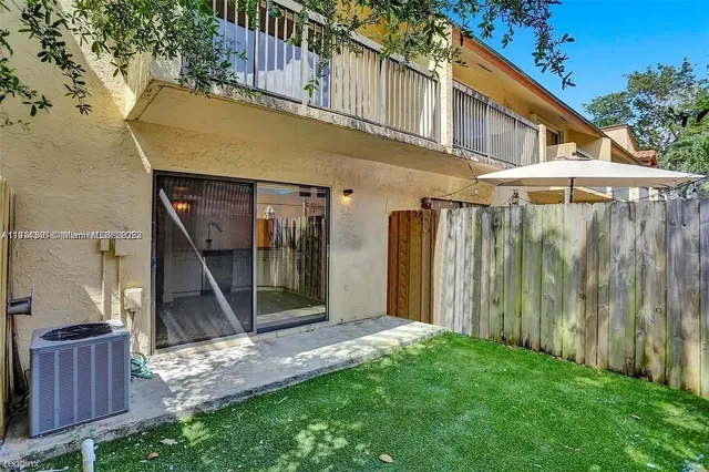 a view of a small house with wooden fence