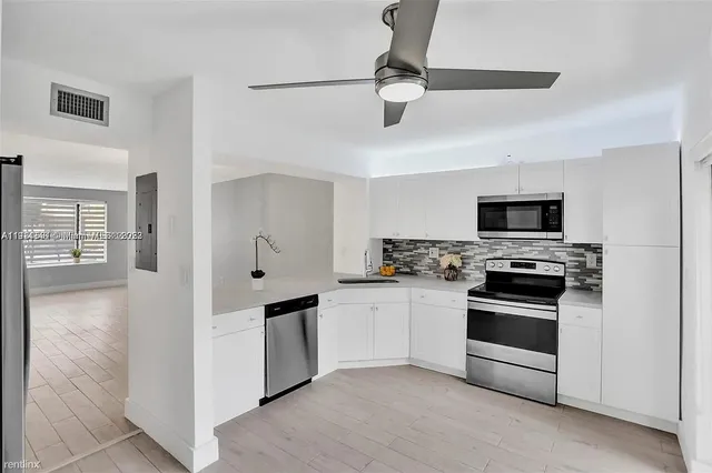 a kitchen with stainless steel appliances and white cabinets