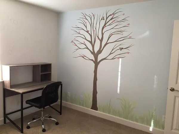 a view of a workspace with furniture and a window