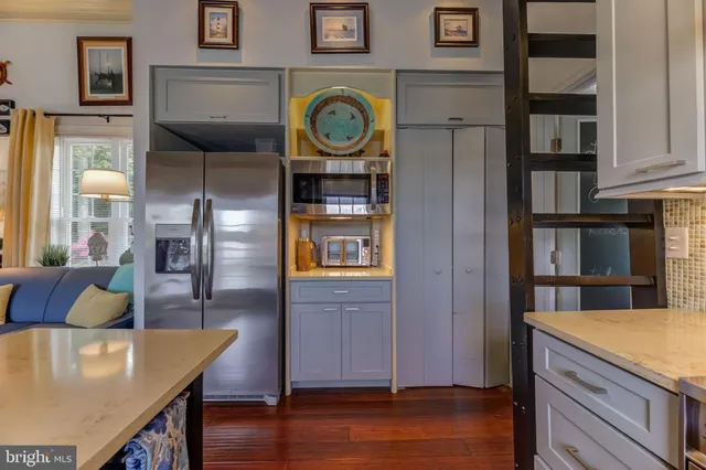 a kitchen with stainless steel appliances granite countertop a refrigerator a stove and a wooden floors