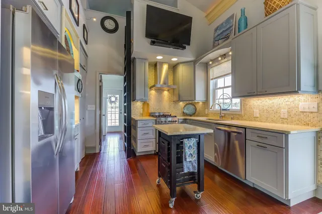 a kitchen with stainless steel appliances granite countertop a sink and wooden floors