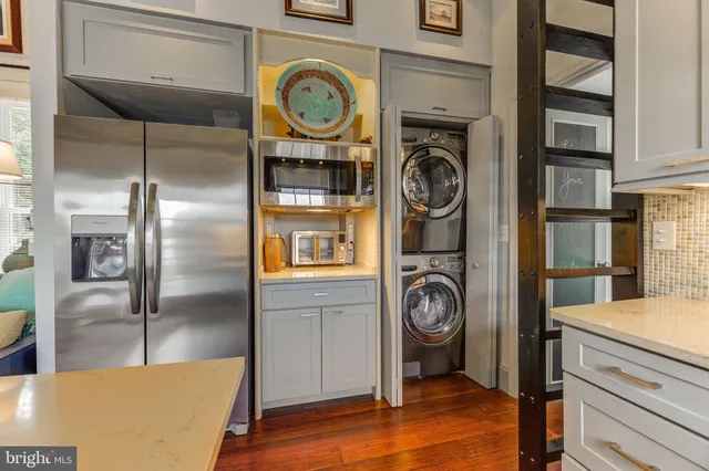 a view of a kitchen fridge and wooden floor
