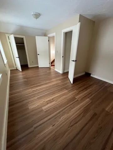 an empty room with wooden floor and entrance