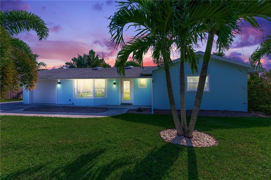 1453 Northwest Spruce Ridge Drive Stuart, FL 34994 - Photo 1 of 27 a front view of a house with garden