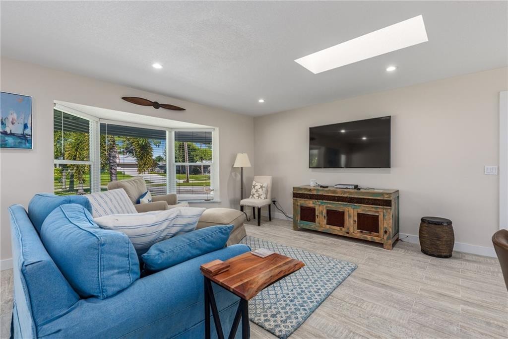 1453 Northwest Spruce Ridge Drive Stuart, FL 34994 - Photo 11 of 27 a living room with furniture a flat screen tv and a fireplace