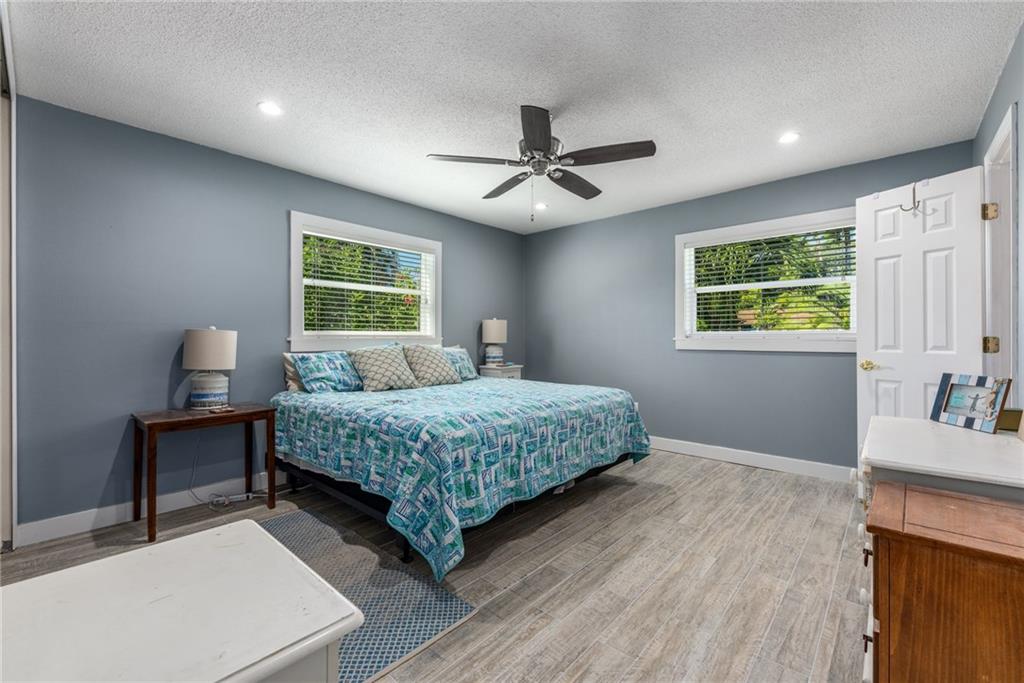 1453 Northwest Spruce Ridge Drive Stuart, FL 34994 - Photo 16 of 27 a bedroom with a bed dresser and a window