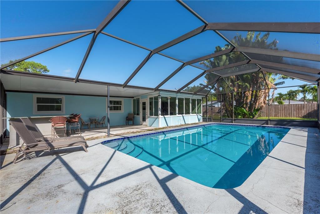 1453 Northwest Spruce Ridge Drive Stuart, FL 34994 - Photo 24 of 27 a view of a patio with a table and chairs under an umbrella