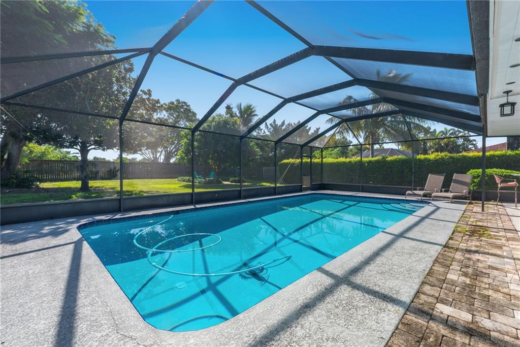 1453 Northwest Spruce Ridge Drive Stuart, FL 34994 - Photo 25 of 27 a view of a swimming pool with a patio and plants