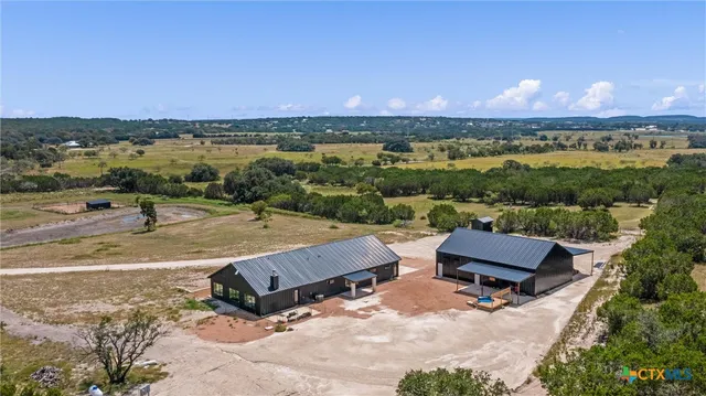 an aerial view of a houses with a yard and lake view