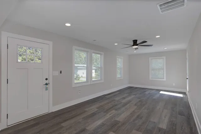 an empty room with wooden floor and a window