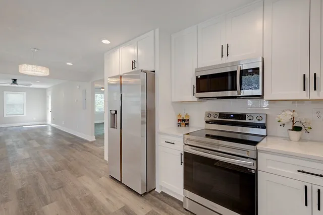 a kitchen with white cabinets a sink and dishwasher