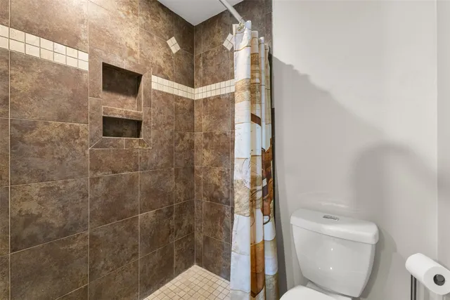a bathroom with a toilet and a shower
