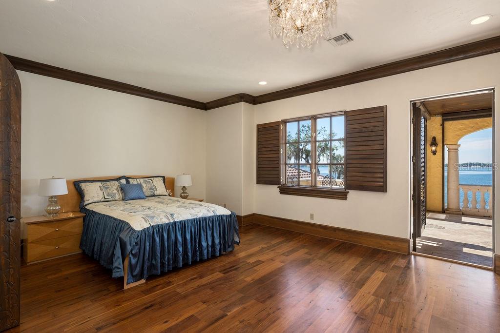 4200 Down Point Lane Windermere, FL 34786 - Photo 52 of 63 a spacious bedroom with a bed a dresser and wooden floor
