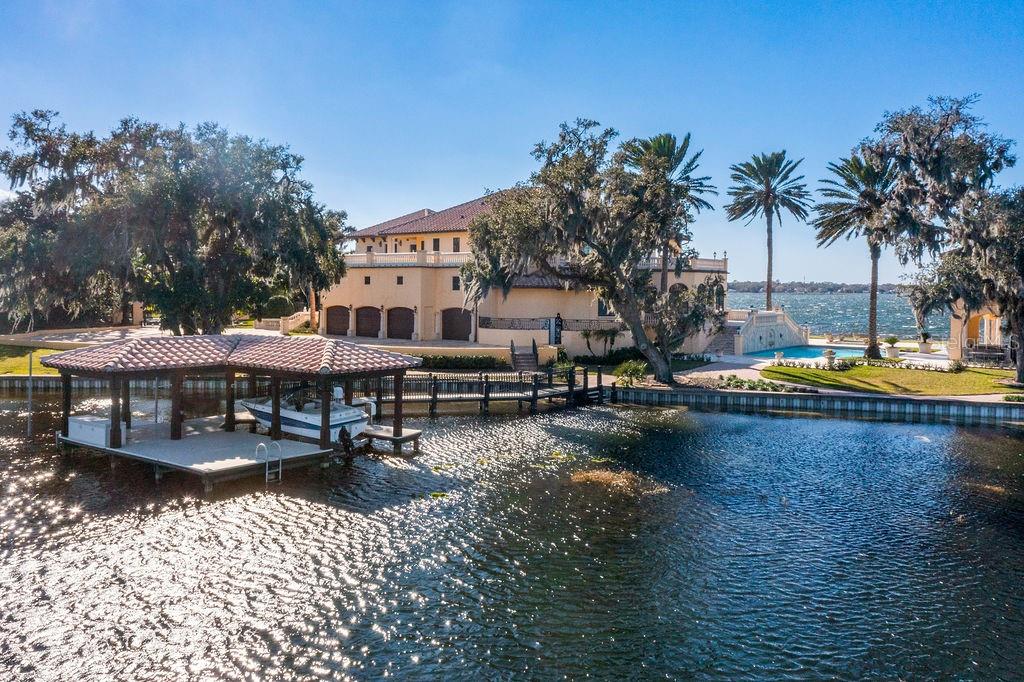 4200 Down Point Lane Windermere, FL 34786 - Photo 7 of 63 a view of a swimming pool with lawn chairs under an umbrella