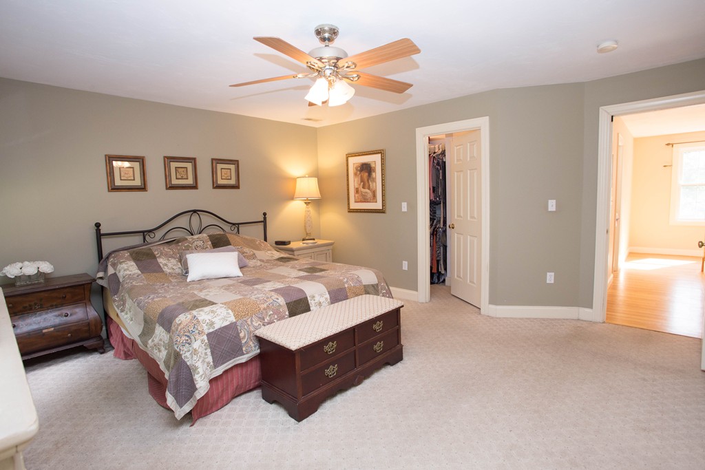 24 Zina Road Hudson, MA 01749 - Photo 13 of 25 a spacious bedroom with a bed and a chandelier
