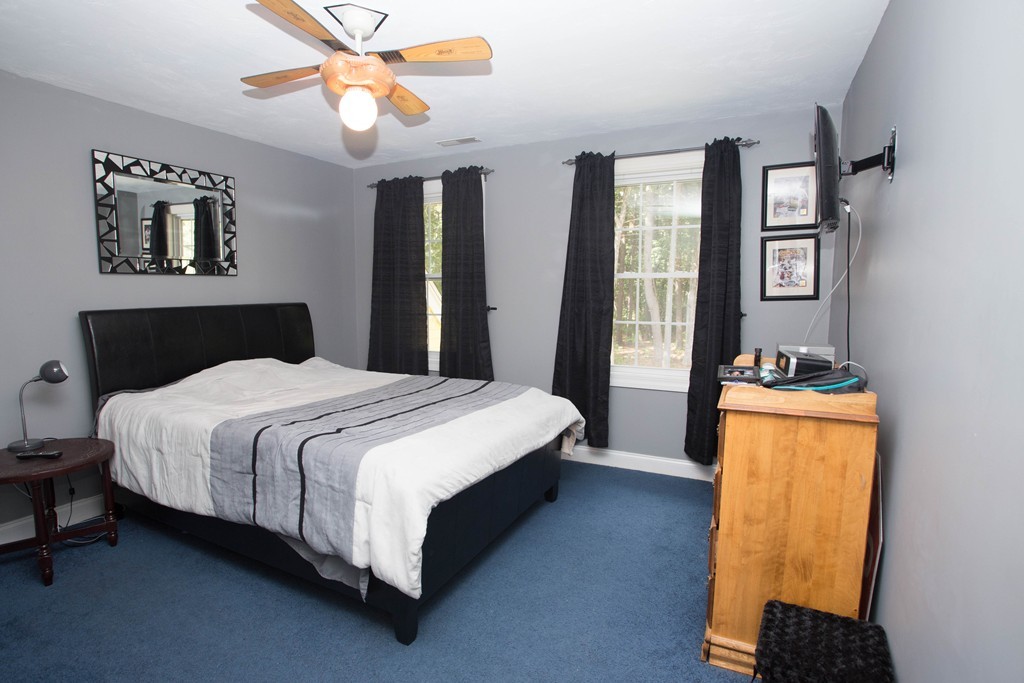 24 Zina Road Hudson, MA 01749 - Photo 16 of 25 a bedroom with a bed lamps and a chandelier