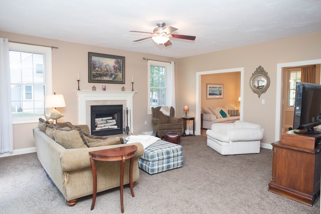 24 Zina Road Hudson, MA 01749 - Photo 5 of 25 a living room with furniture a fireplace and a flat screen tv