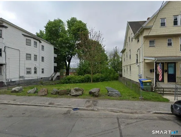 a view of a white house next to a yard