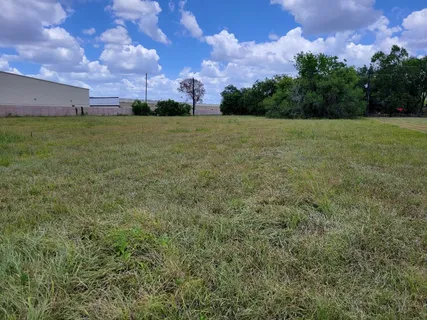 a view of a field with a building in the background