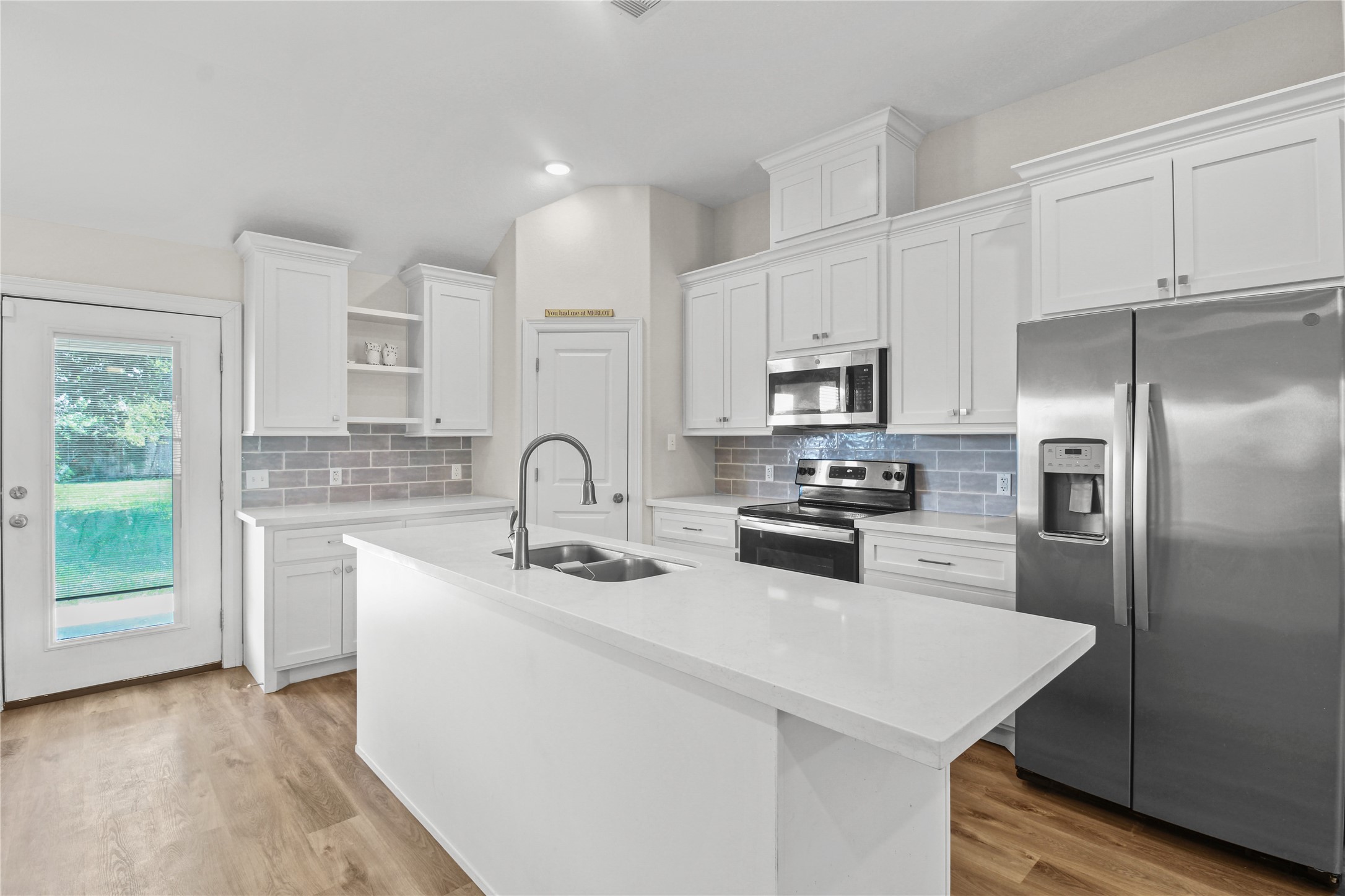 1208 East Henderson Road Angleton, TX 77515 - Photo 8 of 29 a kitchen with kitchen island a white cabinets and stainless steel appliances