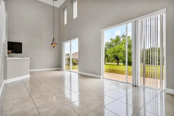 a view of an empty room with a floor to ceiling window and a living room