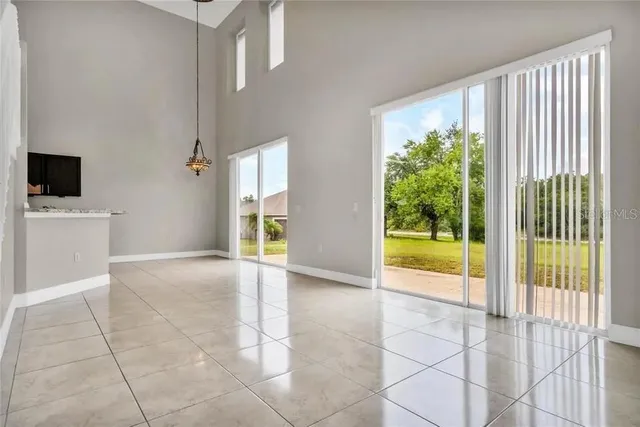 a view of an empty room with a floor to ceiling window and a living room