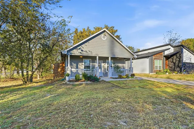 a view of a house with a yard and sitting area