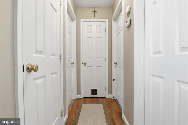 a view of a hallway with wooden floor and closet area