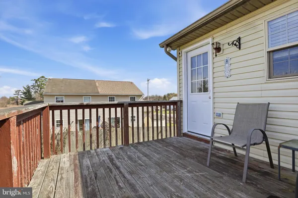 a view of a wooden chairs and bench in the balcony