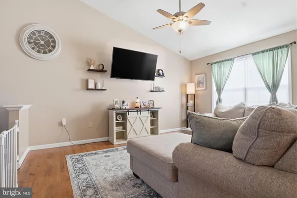 a living room with furniture a flat screen tv and a window