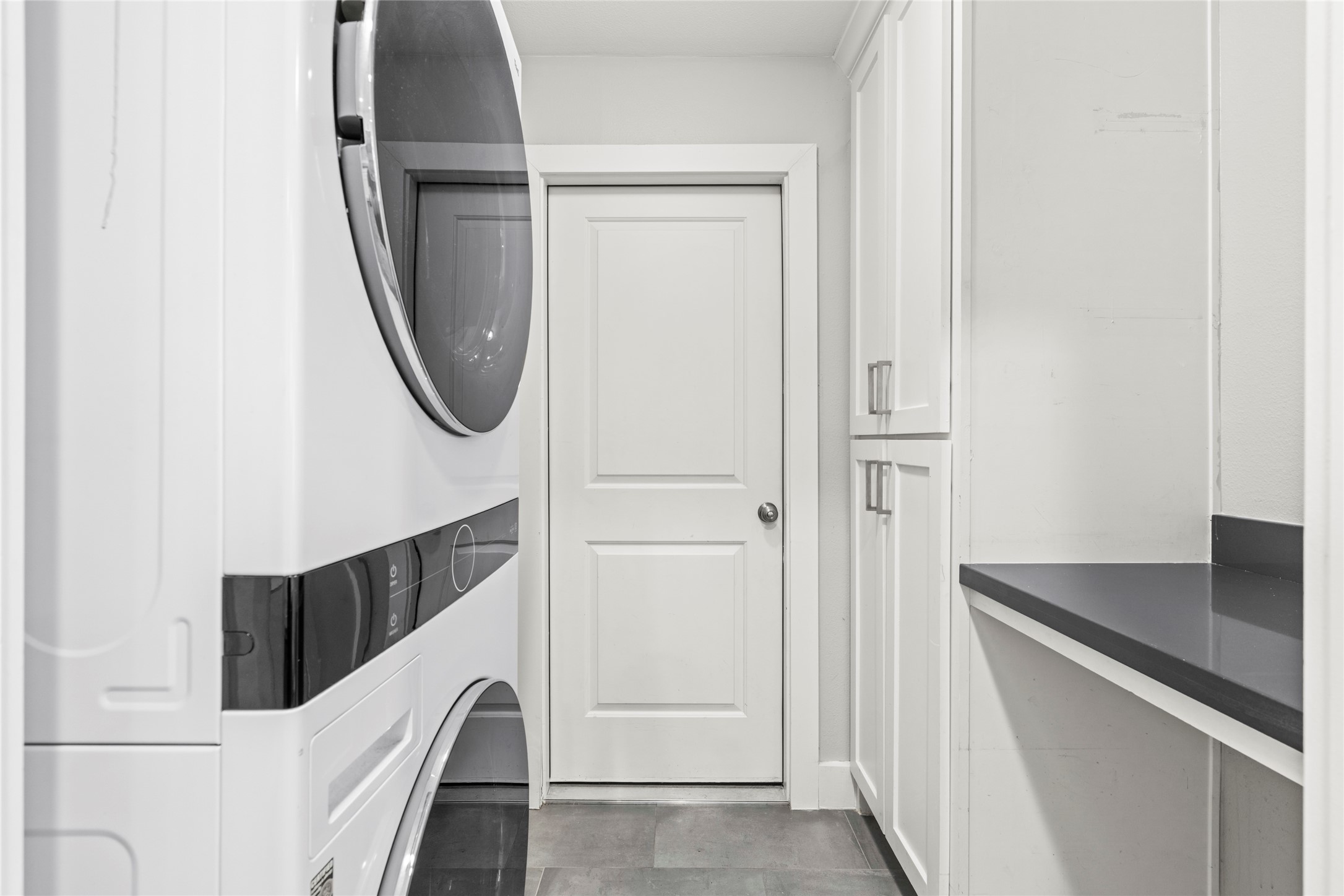 5723 Spellman Road Houston, TX 77096 - Photo 14 of 29 The utility room includes an LG WashTower installed in 2023, built-in cabinetry, countertop space, a storage closet, and access to the attached 2-car garage.