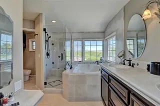 a bathroom with a tub a sink and mirror