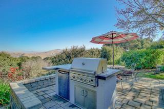 530 Payne Road San Juan Bautista, CA 95045 - Photo 16 of 21 a view of a fireplace with a table and chairs under an umbrella