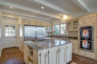 a kitchen with stainless steel appliances granite countertop a kitchen island a stove and a sink