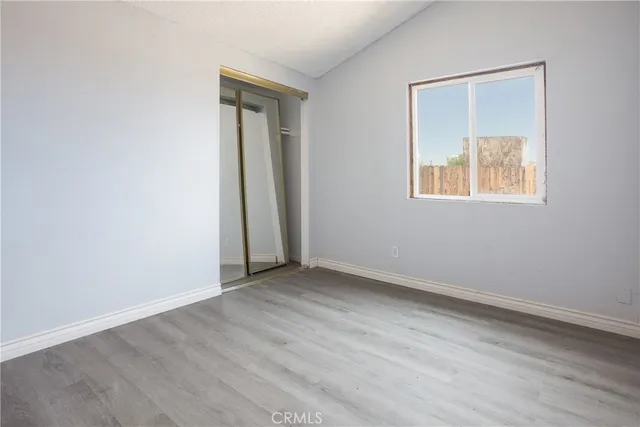 an empty room with wooden floor and a window