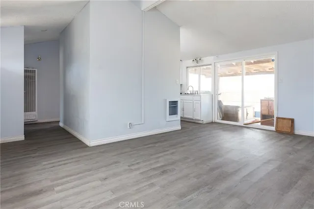 a view of empty room with wooden floor and window
